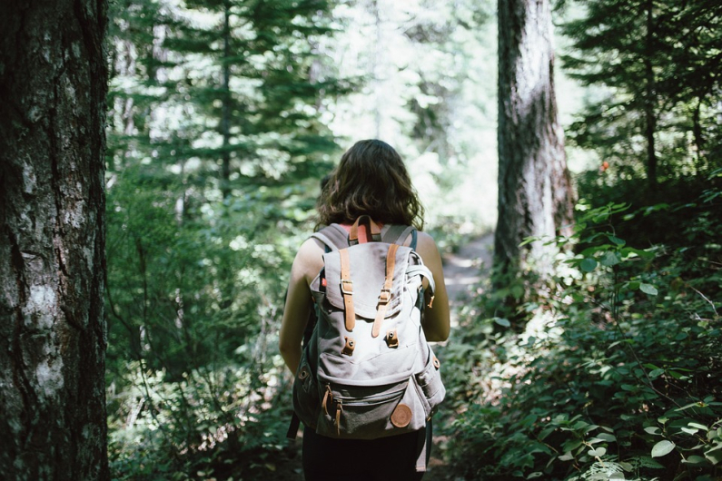 Femme avec son sac à dos en randonnée dans les bois Vignette