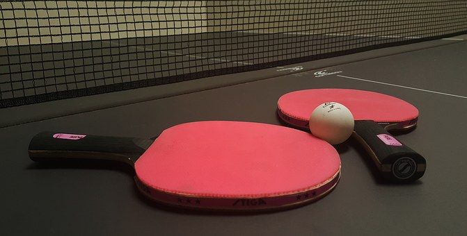 raquettes de ping pong posées sur une table avec balle Vignette