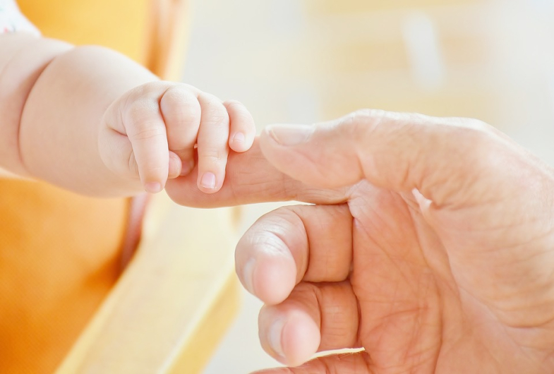 Main d'un enfant soutenue par une main adulte Vignette